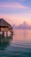 Fototapeta premium Wooden bungalow with thatched roof over turquoise water at sunset, showing quiet luxury and peaceful vacation, perfect for travel or relaxation