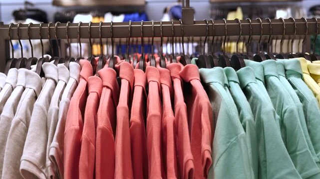 Rows of vibrant polo shirts hanging neatly on a clothing rack in a retail store, showcasing a colorful collection of casual apparel available for purchase in a modern fashion boutique
