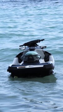 A sleek jet ski poised on tranquil waters: the promise of an exhilarating ride awaits &mdash; feel the rush of the sea breeze, embrace the freedom of open water, and let the adventure begin on this modern w