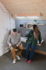 man and woman working in small office