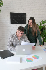 man and woman working in small office