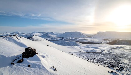 Panoramic view of a snowy mountain landscape under a bright blue sky, sunlit