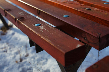 Fototapeta premium Rows of empty wooden benches in an outdoor amphitheater covered with snow during winter season