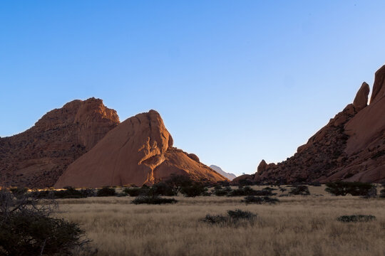 Towering red rock butte rising from desert floor in Namibia