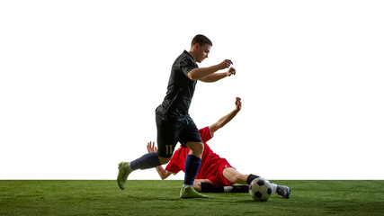 Obraz premium Soccer tackle moment with sliding defender and attacker avoiding contact on white background. Concept of risky defense, last moment challenge, match drama, sports analysis, football media use.