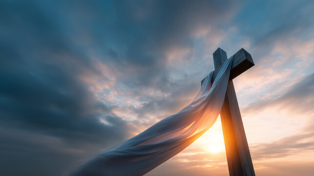 Wooden cross draped with white cloth against dramatic sunrise sky symbol of hope and renewal during holy week christian faith background.