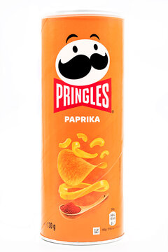 Pringles Paprika flavored potato chips can featuring bright orange packaging with paprika spice imagery and classic branding, showcasing crunchy snack crisps for retail and food marketing use.