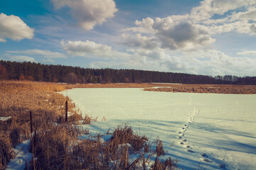 Snowy rural landscape. Frozen lake covered with snow.