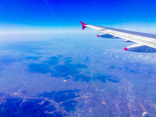 Obraz premium Clouds and sky and Airplane Wing as seen through window of an aircraft