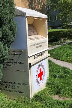 KNUROW, POLAND - MAY 11, 2021: Containers for second-hand clothes recycling operated by Polish Red Cross (Polski Czerwony Krzyz) charity foundation in Poland.