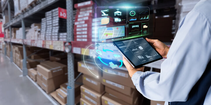 Business Logistics warehouse management system technology concept.Man hands using tablet on blurred warehouse as background