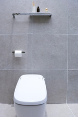 Fototapeta premium A white smart toilet is in the bathroom.