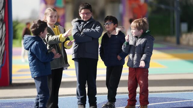 Group of diverse children talking and playing in a playground