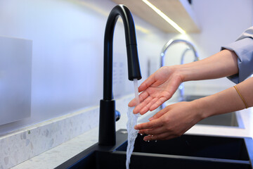 Obraz premium Wash your hands with the black faucet.