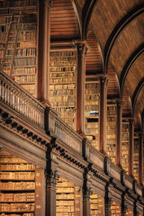 Old library interior with ornate wooden architecture and endless bookshelves © ronnybas
