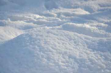Fototapeta premium White snow covered ground texture landscape. Closeup photo outdoors. Winter, nature, natural environment. 