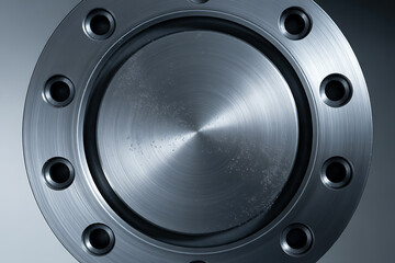 Top-down view of a brushed metal flange with multiple bolt holes, highlighting precision engineering and industrial connection.