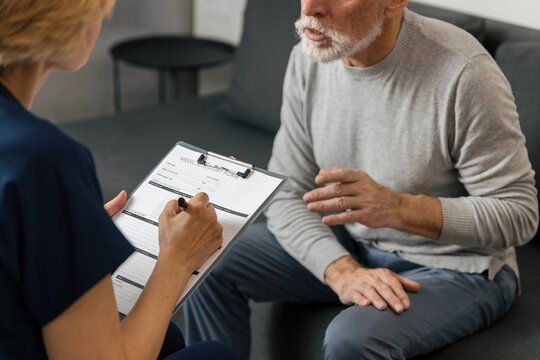 Doctor visits elderly man at home for health consultation and support