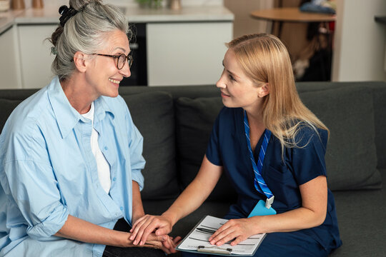 Doctor visits elderly woman at home for health consultation and support