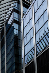 Obraz premium Close-up detail of a modern glass building with blue tones in downtown Manhattan, New York City. Contemporary urban architecture