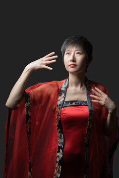 Chinese woman in red dress makes gestures with hands