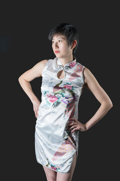 Chinese woman in short white patterned traditional dress staring to her right