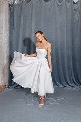 Fototapeta premium Portrait of a beautiful woman in a white semi-short dress