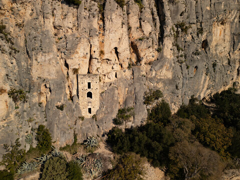 Aerial view of Blaca Hermitage monastery built into a rock cliff on Brac island. Historic stone architecture in Croatia.