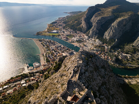 Aerial panoramic view of Omis town and Cetina river canyon in Croatia. Adriatic sea coastline with historic fortress and mountains.