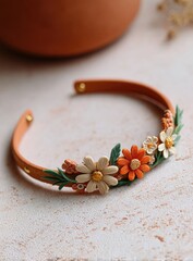 Terracotta bangle adorned with daisy flowers in cream, orange, and touches of green