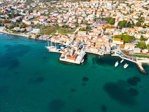 Epic aerial view of the medieval Ka&scaron;tilac fortress in Ka&scaron;tel Gomilica, historic stone castle built in the Adriatic sea, famous film location in Croatia, 4K