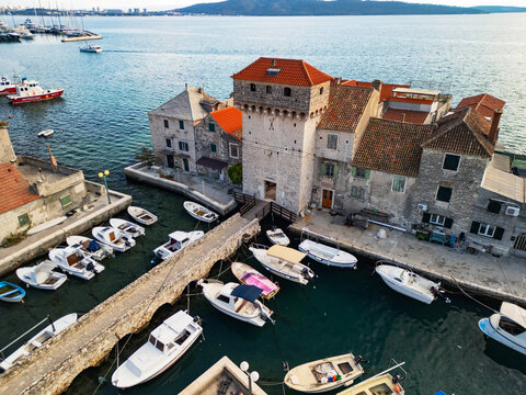 Epic aerial view of the medieval Ka&scaron;tilac fortress in Ka&scaron;tel Gomilica, historic stone castle built in the Adriatic sea, famous film location in Croatia, 4K