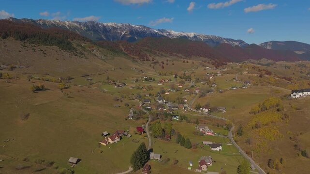 Lateral Aerial Pan Revealing Sirnea Valley and Village Pestera under Snow Capped Piatra Craiului