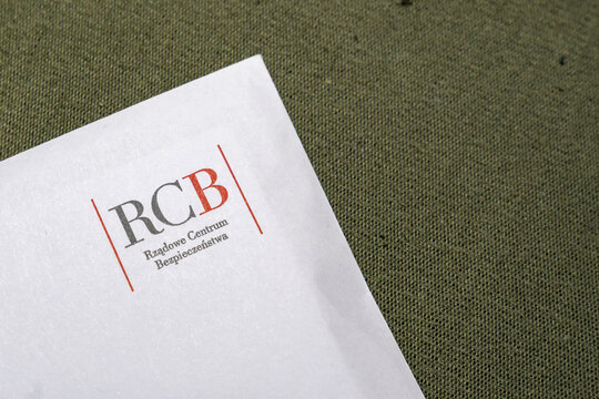 Warsaw, Poland - Jan 29, 2026: A close-up of a letter featuring the logo of RCB, Rzadowe Centrum Bezpieczenstwa, resting on a textured green background.