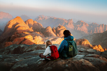 Fototapeta premium Family father and child hiking in mountains travel vacation weekend outdoor dad with child on camping tour together active healthy lifestyle hobby adventure trip parent and kid enjoying views in Egypt