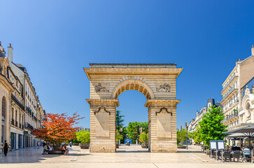 Obraz premium Porte Guillaume Gate Dijon's triumphal arch on Place Darcy Square with green trees in pots in old town Dijon city historical centre in sunny summer day, Bourgogne-Franche-Comte region, France