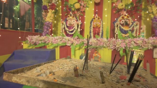 Candle sticks burning in front of idols of Lord Jagannath, Balaram and Suvodra. Indian Rath jatra festival. Howrah, West Bengal, India.