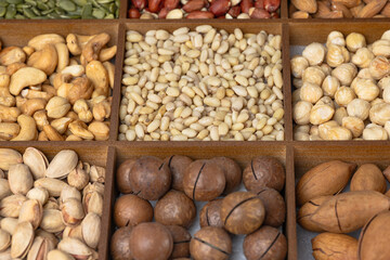 Mixed nut background: pine nuts, pistachios, cashews, almonds, hazelnuts, peanuts, macadamia, pecans,