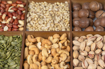 Mixed nut background: pine nuts, pistachios, cashews, almonds, hazelnuts, peanuts, macadamia, pecans,