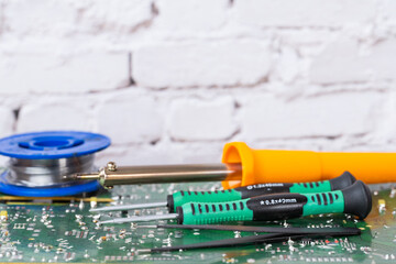 electrical board with a soldering iron and screwdrivers