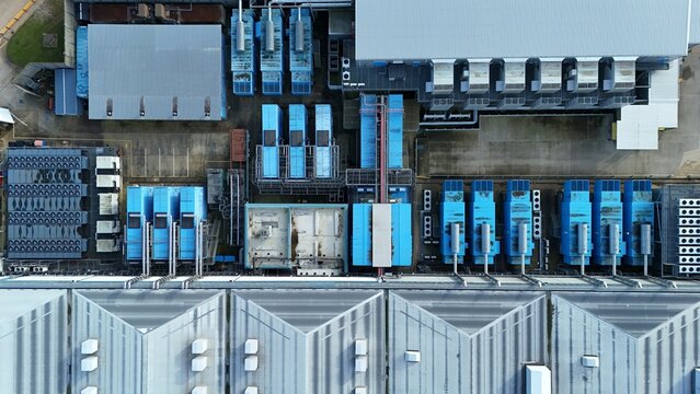 Aerial view of the Colt Data Centre revealing orderly rows of blue and gray structures, a symphony of geometric forms and industrial harmony, Welwyn Garden City, United Kingdom.