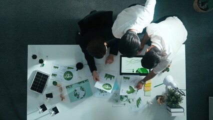Top down view of business team discussing about renewable energy. Aerial view of skilled diverse business people working together to plan about zero waste while using laptop on table. Alimentation. © InfiniteFlow