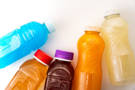 Refreshing colorful sports drinks, juice, and energy beverages in plastic bottles on white background for hydration