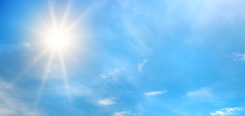 Atmospheric sky view with sunlight radiating outward and white clouds drifting across open space