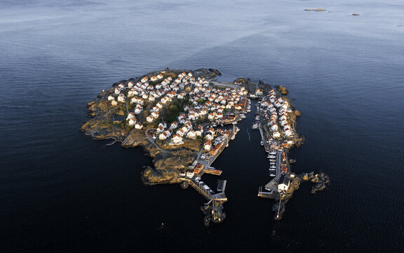 Aerial view of the island's clustered white-roofed houses contrast with the dark, rocky shoreline, nestled in the vast, shimmering sea, &Atilde;&hellip;stol, V&Atilde;&curren;stra G&Atilde;&para;taland County, Sweden.
