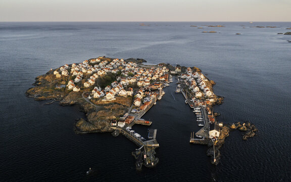 Aerial view of houses with white roofs stand in contrast to the dark blue sea, a serene island community nestled in the archipelago, &Atilde;&hellip;stol, V&Atilde;&curren;stra G&Atilde;&para;taland County, Sweden.