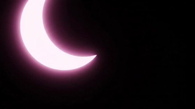 Partial Solar Eclipse Crescent Moon Shape Glowing Pink Light in Dark Sky
