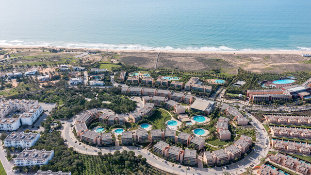 Explore the Salgados area in Albufeira from above, showcasing the coastline, resort buildings, and surrounding landscape in the Algarve region