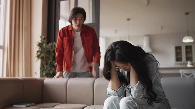 Young Asian man shouting at crying girlfriend showing psychological abuse
