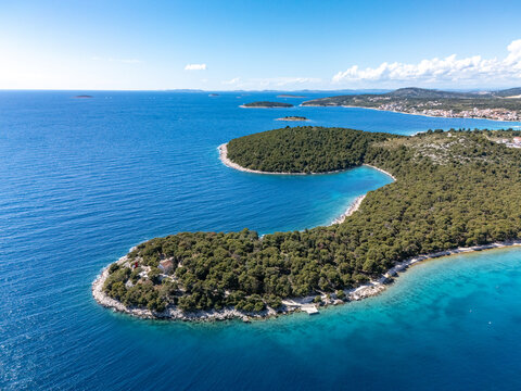 Aerial view of the Dragon's Eye Lake and the vibrant green peninsula contrast against the deep blue Adriatic Sea, creating a stunning coastal panorama, Rogoznica, Croatia.